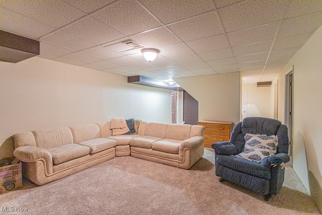 carpeted living room with a drop ceiling