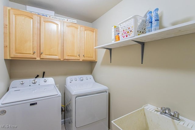 laundry room featuring cabinets, separate washer and dryer, and sink