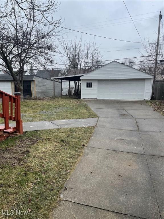 exterior space with an outbuilding, a garage, a carport, and a front yard