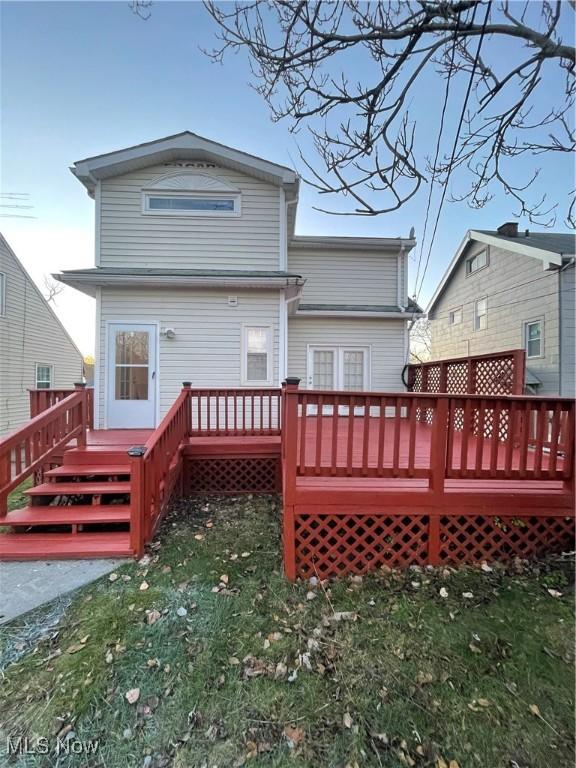 rear view of house with a lawn and a deck