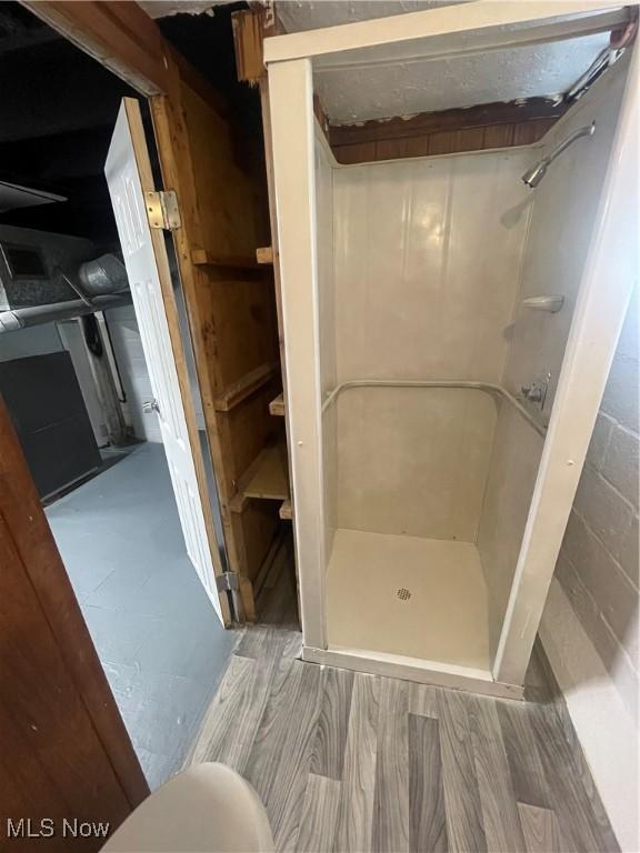 bathroom with hardwood / wood-style flooring and walk in shower