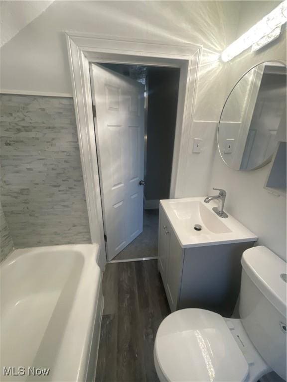 bathroom featuring a bathing tub, vanity, toilet, and hardwood / wood-style floors