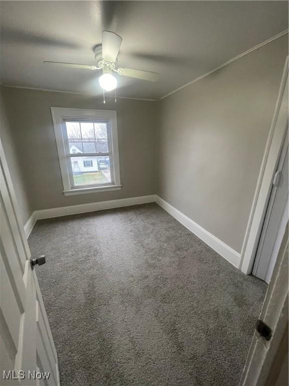 carpeted spare room featuring crown molding and ceiling fan