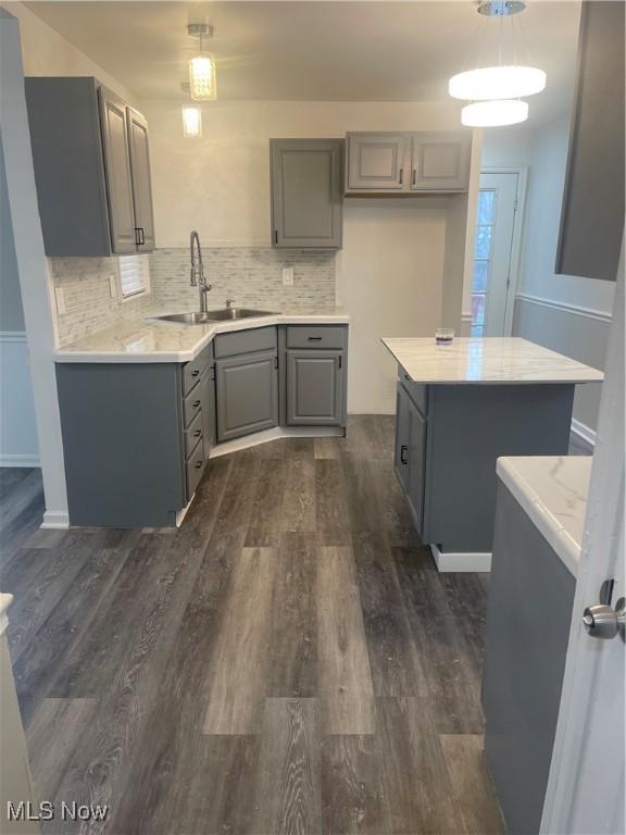 kitchen with gray cabinetry, sink, and pendant lighting