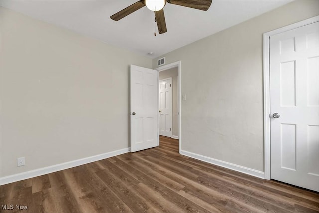 unfurnished bedroom with ceiling fan and dark hardwood / wood-style floors