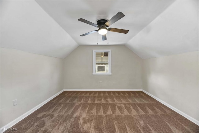 bonus room with dark colored carpet, vaulted ceiling, and ceiling fan