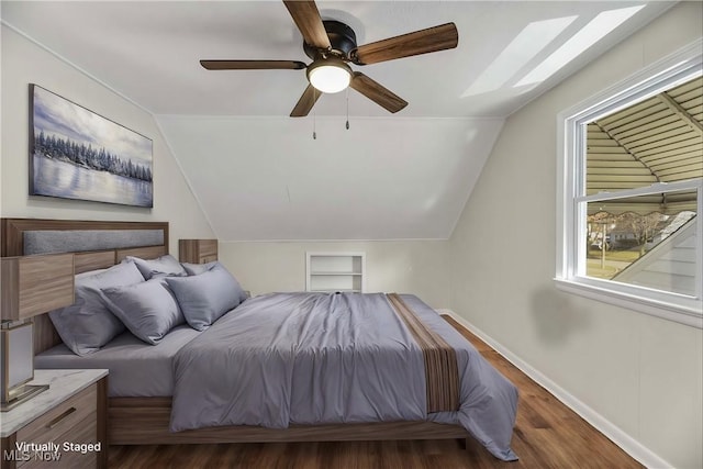 bedroom featuring lofted ceiling with skylight, ceiling fan, and dark wood-type flooring