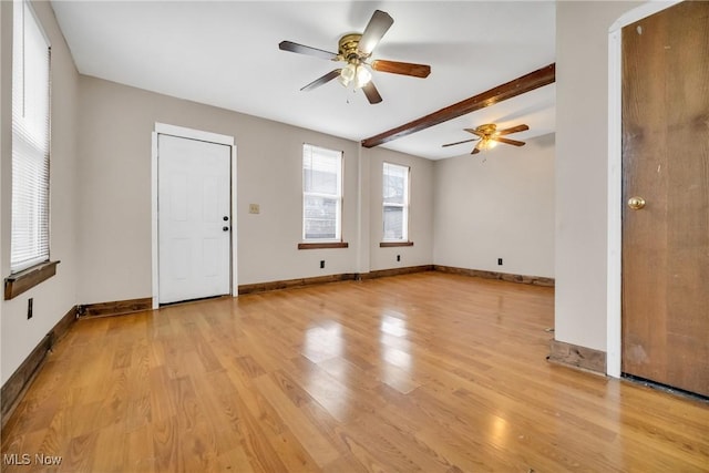 empty room featuring beamed ceiling, light hardwood / wood-style flooring, and ceiling fan