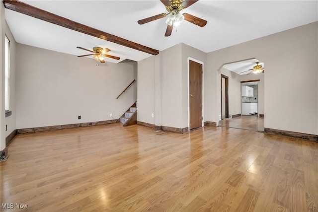 spare room featuring beam ceiling and light hardwood / wood-style flooring