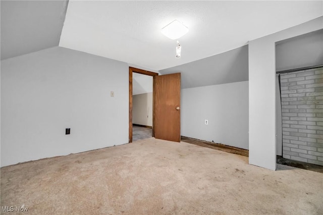 additional living space with light carpet and vaulted ceiling