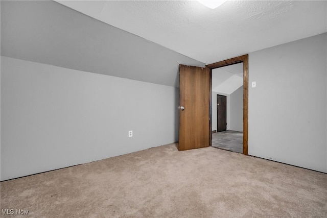 bonus room featuring lofted ceiling and light carpet