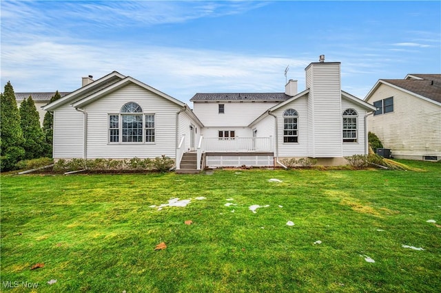 rear view of property featuring a lawn