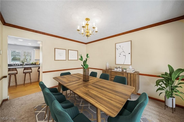 dining space featuring a textured ceiling, light colored carpet, an inviting chandelier, and crown molding