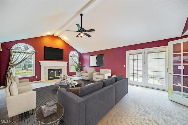 living room featuring a tile fireplace, vaulted ceiling with beams, a wealth of natural light, and ceiling fan