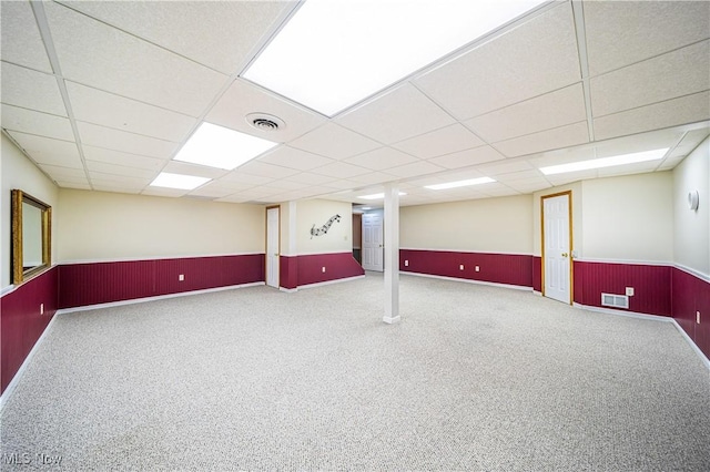 basement featuring carpet and a paneled ceiling