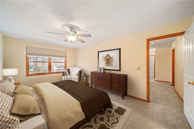 bedroom featuring ceiling fan, light carpet, and a textured ceiling