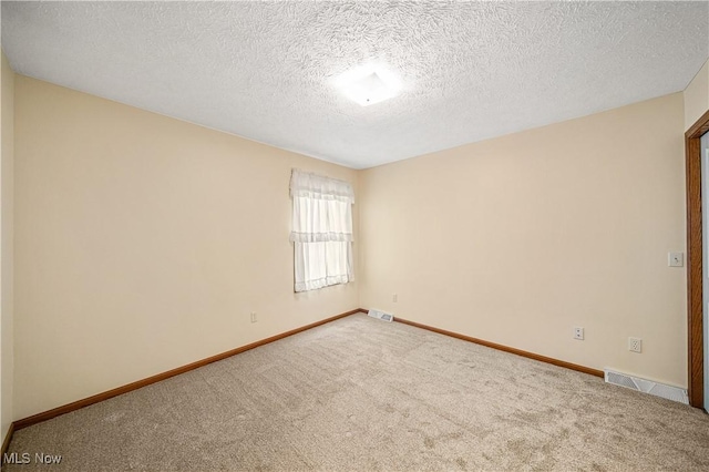 unfurnished room with carpet flooring and a textured ceiling