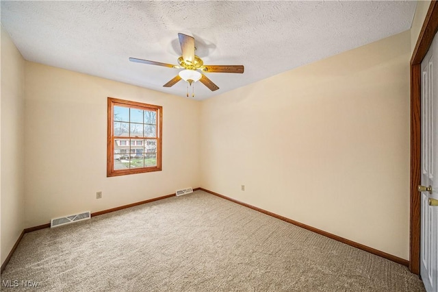 spare room with carpet flooring, ceiling fan, and a textured ceiling