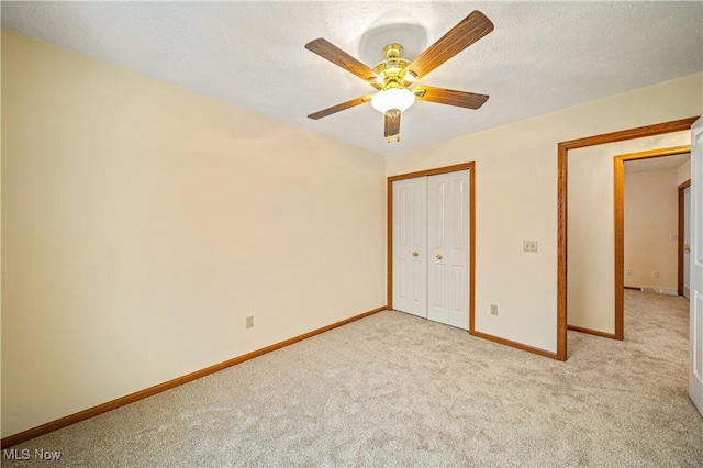 unfurnished bedroom featuring ceiling fan, light colored carpet, and a closet