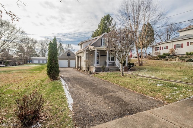 view of front of house with a garage, an outbuilding, and a front yard