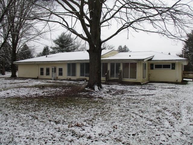 snow covered house with a sunroom