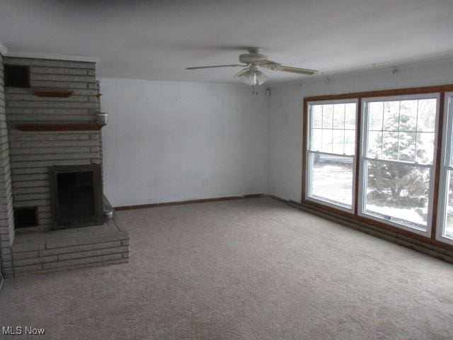 unfurnished living room with a fireplace, carpet, and ceiling fan