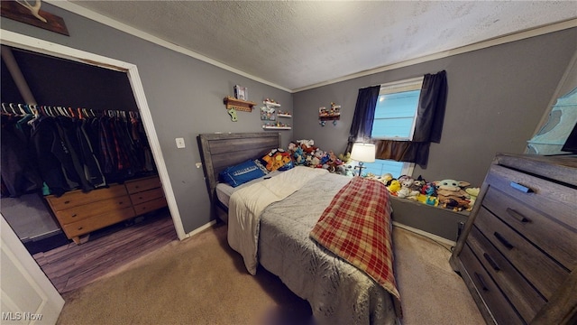 carpeted bedroom featuring a textured ceiling, a closet, and ornamental molding