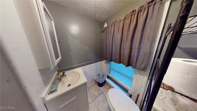 bathroom featuring vanity, a textured ceiling, tile patterned floors, and toilet