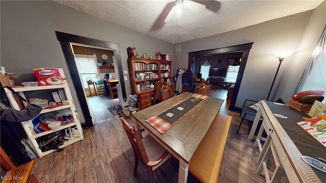 dining area featuring a textured ceiling, ceiling fan, and dark wood-type flooring