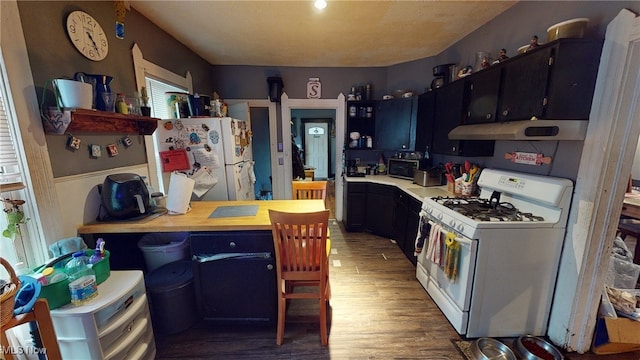 kitchen featuring white appliances and dark hardwood / wood-style floors