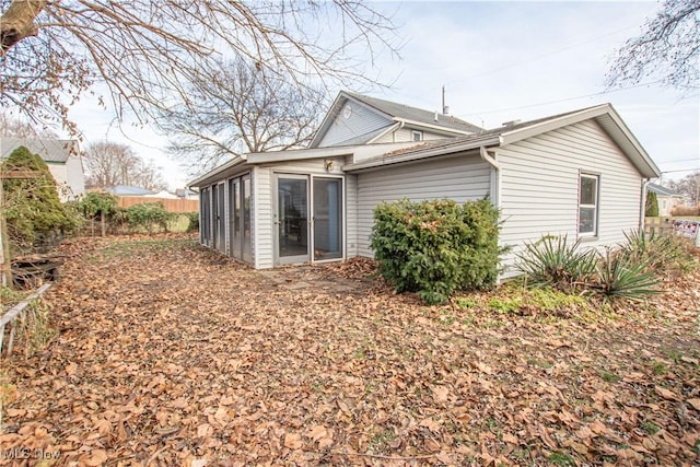 rear view of house featuring a sunroom