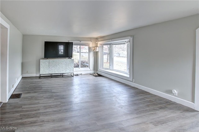 unfurnished living room with hardwood / wood-style flooring and a baseboard radiator