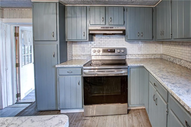 kitchen with stainless steel range with electric stovetop, gray cabinets, light stone counters, and light wood-type flooring