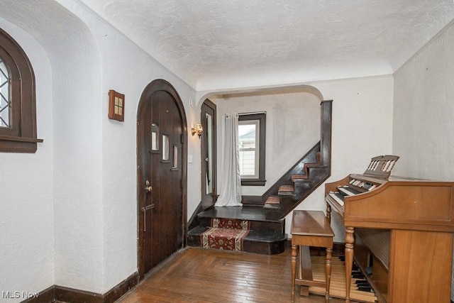 foyer entrance with wood-type flooring and a textured ceiling