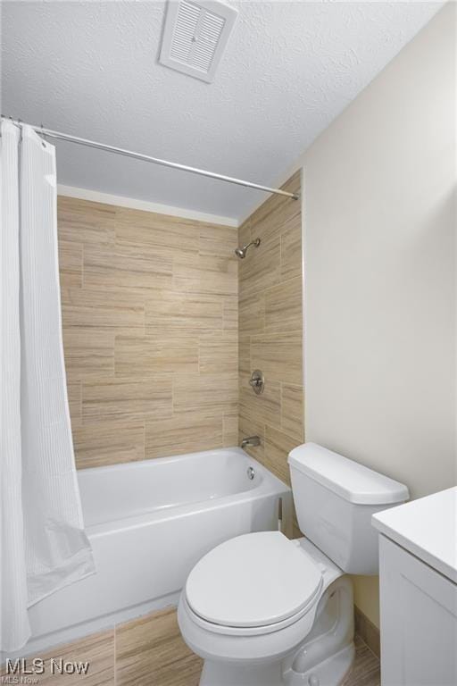 full bathroom with vanity, a textured ceiling, shower / tub combo with curtain, hardwood / wood-style flooring, and toilet