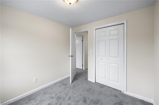 unfurnished bedroom featuring light carpet and a closet