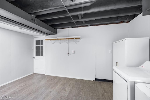 laundry area with hardwood / wood-style flooring and washing machine and clothes dryer