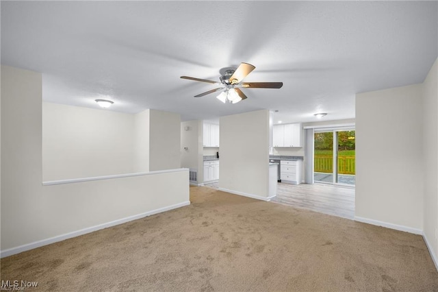 unfurnished living room featuring light colored carpet and ceiling fan