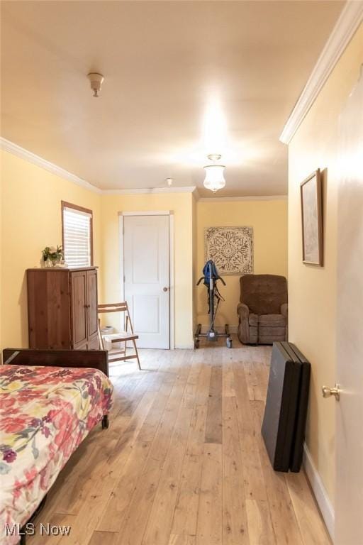 bedroom featuring crown molding and light hardwood / wood-style flooring