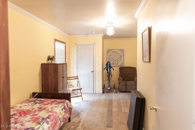 bedroom with light wood-type flooring and ornamental molding