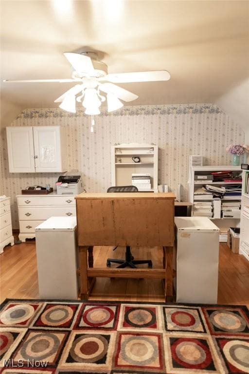 interior space with white cabinetry, ceiling fan, light hardwood / wood-style floors, lofted ceiling, and a kitchen island