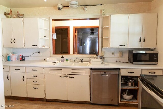 kitchen featuring appliances with stainless steel finishes, light hardwood / wood-style floors, white cabinetry, and sink