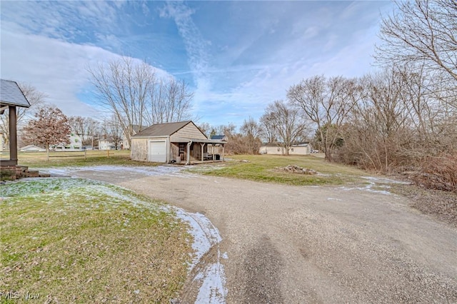 view of front of house with an outbuilding, a front lawn, and a garage