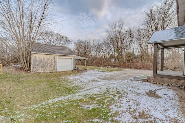 view of yard featuring an outbuilding, a carport, and a garage