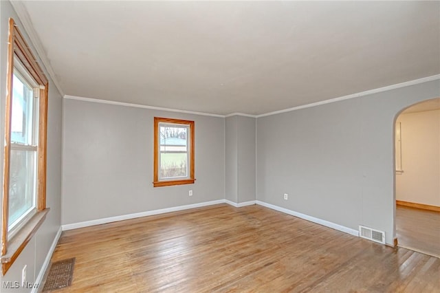 spare room featuring ornamental molding and light wood-type flooring