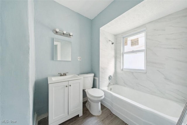 full bathroom featuring tiled shower / bath, toilet, vanity, and hardwood / wood-style flooring