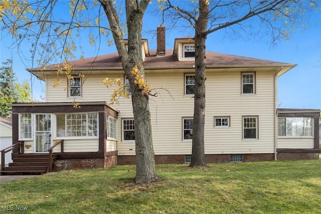 rear view of property with a sunroom and a yard