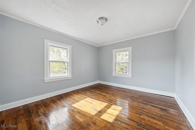 empty room featuring dark hardwood / wood-style flooring and ornamental molding