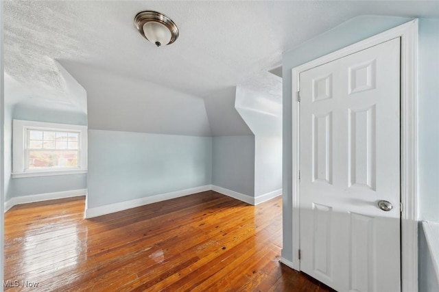 additional living space featuring hardwood / wood-style floors and lofted ceiling