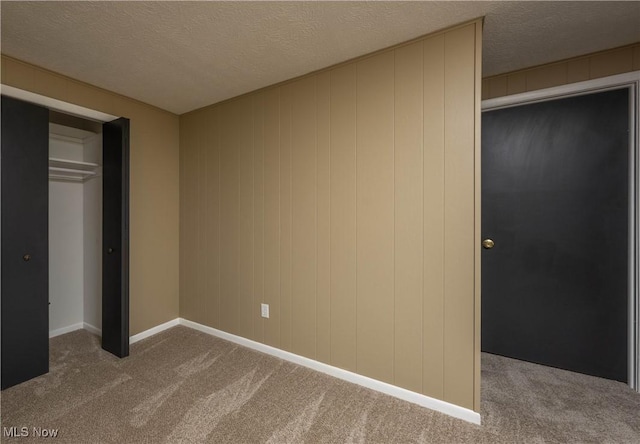 unfurnished bedroom with a textured ceiling, carpet floors, and a closet